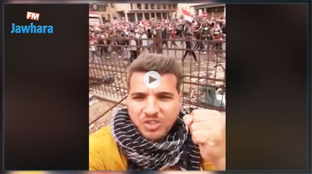 على صوت الرصاص و قنابل الغاز.. عراقي يؤدي أغنية وطنية وسط المتظاهرين (فيديو)