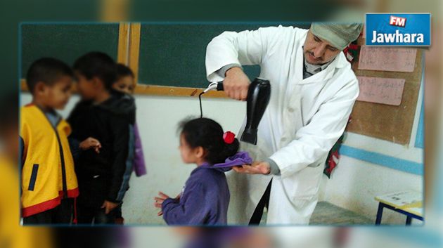 معلم يجفف شعر و ثياب تلاميذه بعد أن بللتهم الأمطار