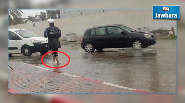 صورة اليوم : شرطي حافيا وسط الأمطار